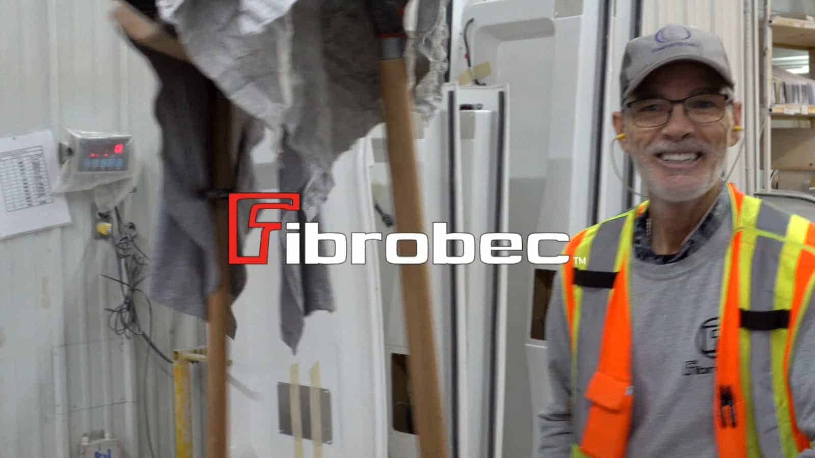 Travailleur en gilet de sécurité orange fluorescent souriant dans une usine de fibres de verre Fibrobec