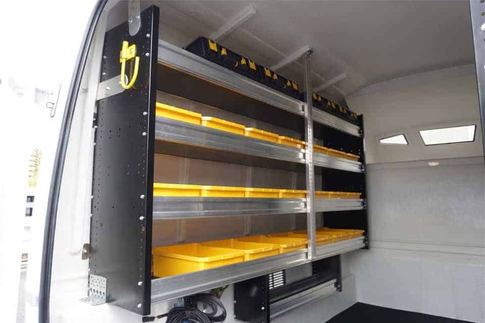 Étagères métalliques avec bacs de rangement jaunes installées à l'intérieur d'une camionnette utilitaire